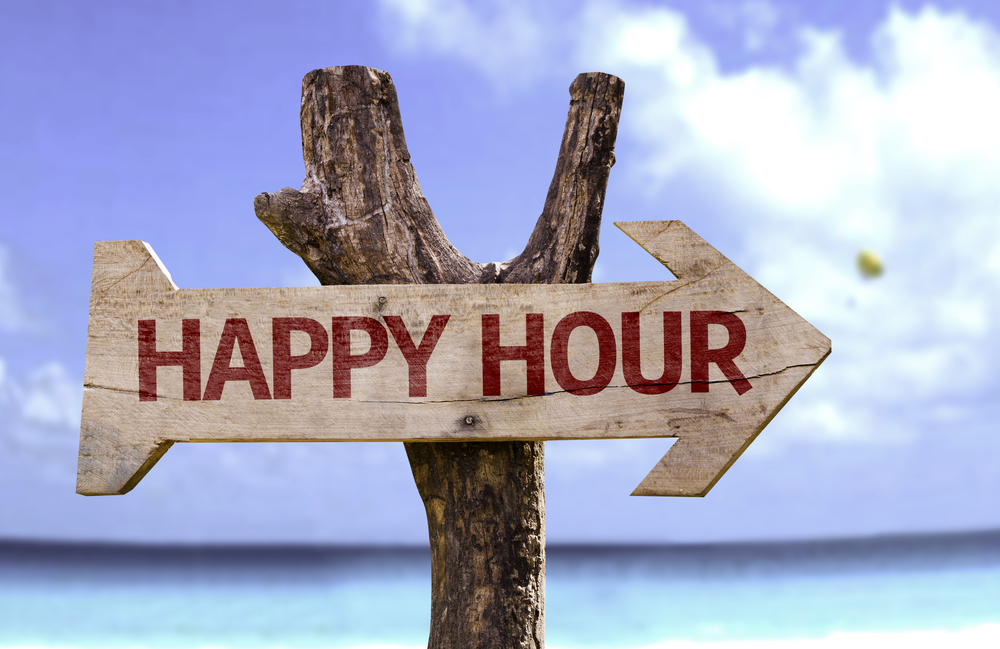 October Happy Hour wooden sign with a beach on background